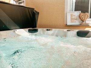 a bath tub filled with water next to two toilets at Panorama-Refugium in Bad Koetzting