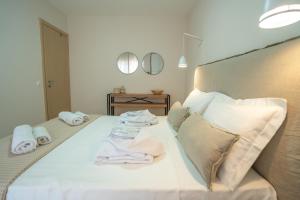 a bedroom with a white bed with towels on it at Elia Family Apartment in Neos Marmaras