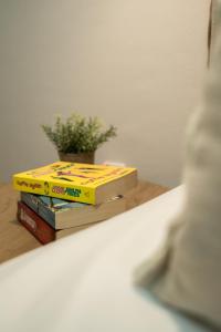 a stack of books sitting on a shelf with a plant at Elia Family Apartment in Neos Marmaras