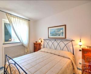 1 dormitorio con cama y ventana en Villino Blu en Praiano