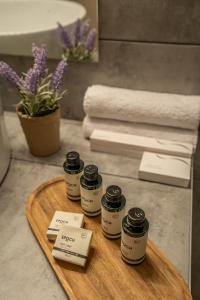 a wooden tray with five jars on a bathroom counter at Elia Family Apartment in Neos Marmaras +34 photos