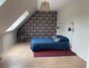 um quarto com uma cama azul num sótão em La clef des champs em Gruson