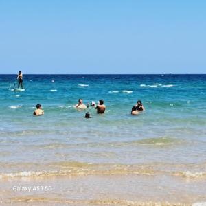 un grupo de personas en el agua en la playa en Masseria li Vecchi, en Squinzano