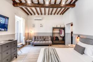 een slaapkamer met een bed en een bank bij Costaguti 36 Apartment in Rome