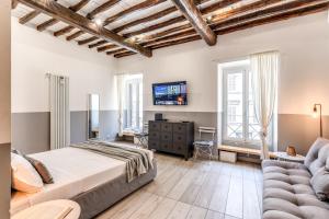 ローマにあるCostaguti 36 Apartmentのベッドルーム(ベッド1台、ソファ、テレビ付)