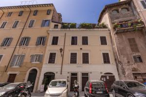 budynek z samochodami zaparkowanymi przed nim w obiekcie Costaguti 36 Apartment w Rzymie