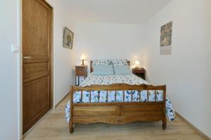 Cour-Maugis-sur-HuisneにあるCozy Perche - Maison avec jardinのベッドルーム1室(木製ベッド1台、青い枕付)