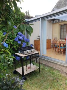 a grill sitting on a table in a garden at Maison dans le bourg in Les Pieux