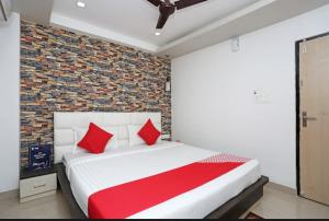 um quarto com uma cama grande e almofadas vermelhas em SSJ Premium em Bhubaneshwar