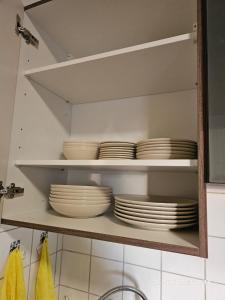 a cupboard filled with white plates and bowls at Komfortable 3-Zimmer-Wohnung in Neubeckum in Beckum