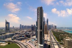 Avani Plus Palm View Dubai Hotel & Suites في دبي: اطلالة على مدينة ذات مبنى طويل