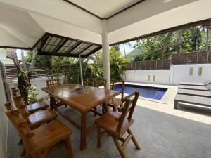 a patio with a table and chairs and a pool at Orchid Villa in Ko Tao
