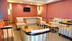 a waiting room with couches and chairs and a tv at Lima Hotel in Phra Nakhon Si Ayutthaya