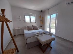 a white bedroom with a bed and a window at Villa Evriali in Plakias