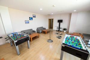 a living room with two tables and a room with a chessboard at Sport Plaza Hotel & Apartments in Baku