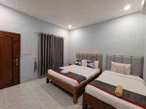 a bedroom with two beds and a window at 83 Guesthouse in Bahal