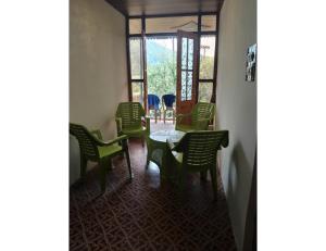 une salle à manger avec des chaises vertes et une table dans l'établissement Ikhlas guest house, Srinagar, à Srinagar