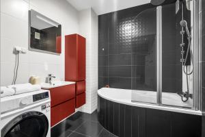 a bathroom with a tub and a washing machine at Warsaw Apartments - Parking, Quiet Neighbourhood - by Rentujemy in Warsaw