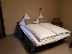 1 cama con sábanas blancas y almohadas en una habitación en Boardinghouse Marktplatz en Schwandorf in Bayern