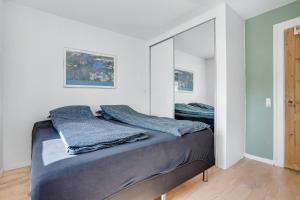 łóżko w pokoju z lustrem w obiekcie Apartment in central Holstebro w mieście Holstebro