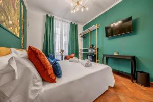 1 dormitorio con cama blanca y paredes verdes en Colosseo Relais en Roma