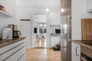 een keuken met een koelkast en een tafel met stoelen bij Apartment in central Holstebro in Holstebro
