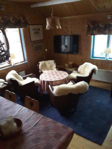 a living room with chairs and a table and a tv at Vemdalsskalsgården in Vemdalen