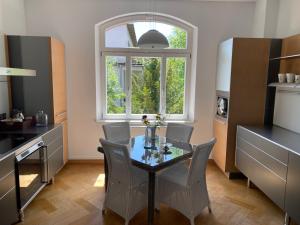 cocina con mesa, sillas y ventana en Helsinki Apartment 2, en Erfurt