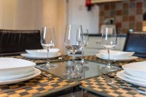 a table with empty wine glasses and plates on it at Chesterfield Lodge - 2 Bedroom Apartment near Chesterfield Town Centre in Chesterfield