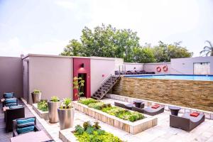 um quintal com uma piscina e uma casa em Southern Sun Rosebank em Joanesburgo