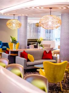 a lobby with couches and chairs and chandeliers at Southern Sun Rosebank, Johannesburg in Johannesburg +90 photos
