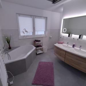 een witte badkamer met een bad en een wastafel bij Ferienapartment 21 in Kurort Gohrisch