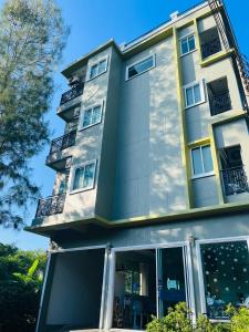 an apartment building with a large window at Nature Pine Phuket เนเชอร์ไพน์ภูเก็ต in Rawai Beach +14 photos