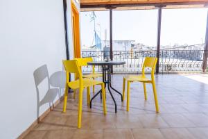 a table and chairs on a balcony with a view at Mondrian Guest House in Skiathos