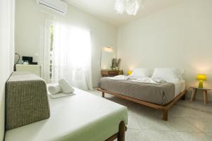 a white bedroom with a bed and a window at Mondrian Guest House in Skiathos