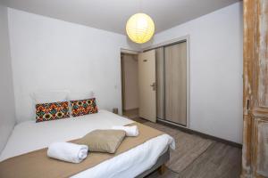 een slaapkamer met een groot wit bed en een kroonluchter bij Spacieux appartement de 70 m2, 2 chambres, au calme proche du Vieil Antibes in Antibes