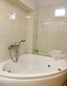 e bagno con vasca e doccia. di Matina Hotel a Mykonos Città