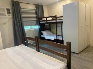 Zimmer mit 2 Etagenbetten und einem Schrank in der Unterkunft ABE Lodge Taguig in Manila