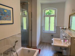 y baño con bañera, lavamanos y ducha. en Helsinki Apartment 2, en Erfurt