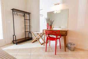 a room with a table and red chairs and a mirror at Mondrian Guest House in Skiathos