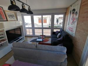 a living room with a couch and a tv at appartement 50 m2 vue mer in Villers-sur-Mer