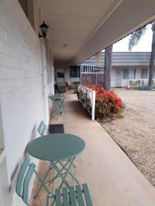 un patio con mesa y sillas en el lateral de un edificio en Aromet Motor Inn, en Temora