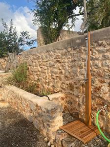 um chuveiro numa parede de pedra com um banco de madeira em Agroturismo rural Can Prats em Sant Carles de Peralta