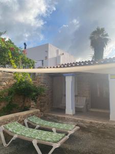 2 ligstoelen op de patio van een huis bij Agroturismo rural Can Prats in Sant Carles de Peralta