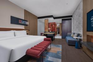 a hotel room with a bed and a living room at Hotel Indigo Changsha Meixi Lake in Changsha