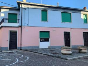 Edificio rosa y azul con ventanas con contraventanas verdes en Holiday Home, en Belmonte del Sannio