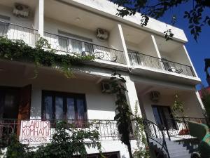 ein weißes Gebäude mit Balkonen und einem Schild darauf in der Unterkunft Guest House Buche on Agmashenebeli 219 in Kobuleti