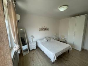 - une chambre blanche avec un lit et un miroir dans l'établissement Casa Linda, à Cupello