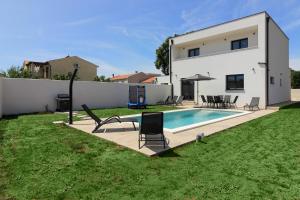 Un patio trasero con piscina y una casa. en Villa Relax II with private pool near the town and the beach by WiiBuk, en Šišan