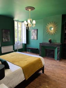 Dormitorio verde con cama y chimenea en Château Lamothe, en Baziège